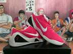 Pair of pink and white Nike Kobe basketball shoes shown from the side