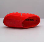 Top view of an orange-red Nike slide showing the footbed, perforated upper and branding.