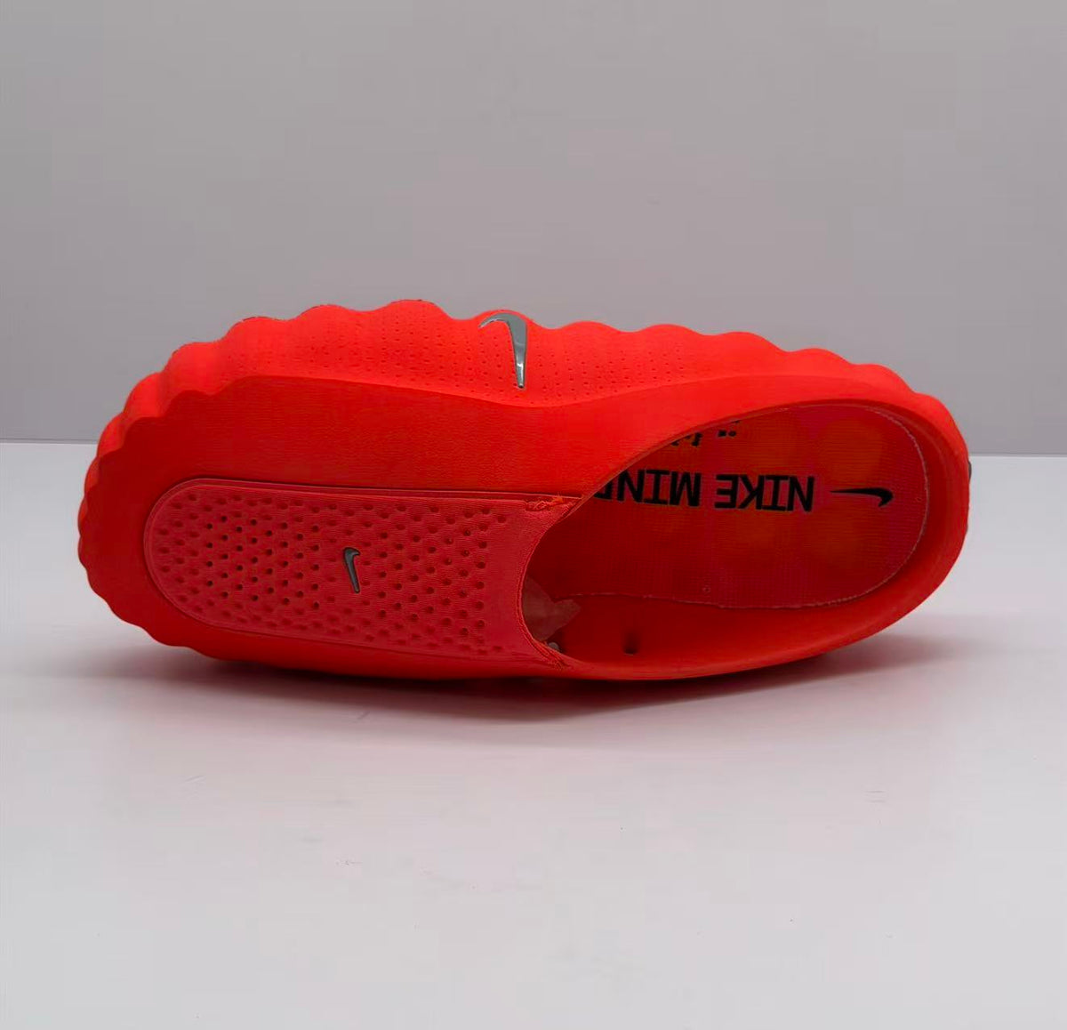 Top view of an orange-red Nike slide showing the footbed, perforated upper and branding.