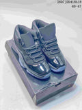 Pair of dark Jordan Air Jordan 11 Retro high-top sneakers displayed on a shoebox, with the source-marked range 40–47 visible at the top.