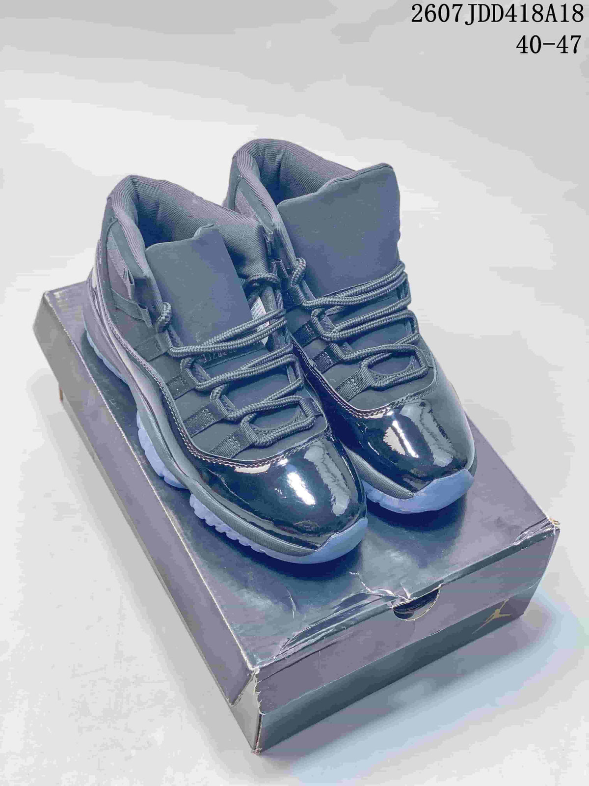 Pair of dark Jordan Air Jordan 11 Retro high-top sneakers displayed on a shoebox, with the source-marked range 40–47 visible at the top.