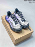 Pair of Salomon Genesis trail running shoes in black, purple, white, and gray, displayed on a Salomon shoebox.