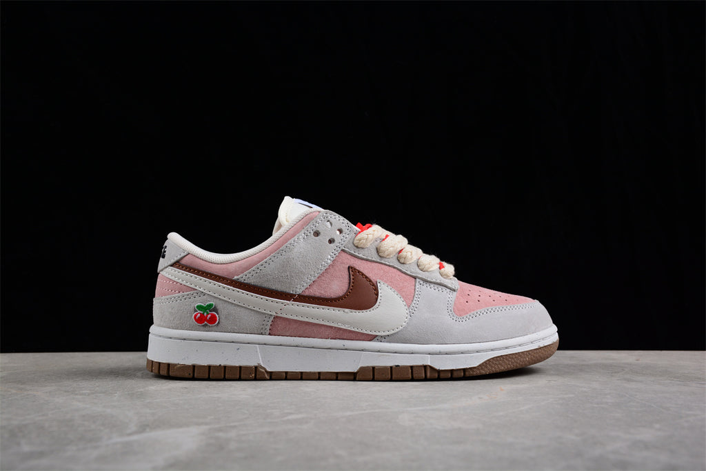 Lateral side profile with pink and gray panels, brown and white Swoosh elements, and cherry embroidery.