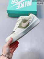 Side profile showing the low-top shape, contrasting side branding, layered upper panels, and rubber outsole.
