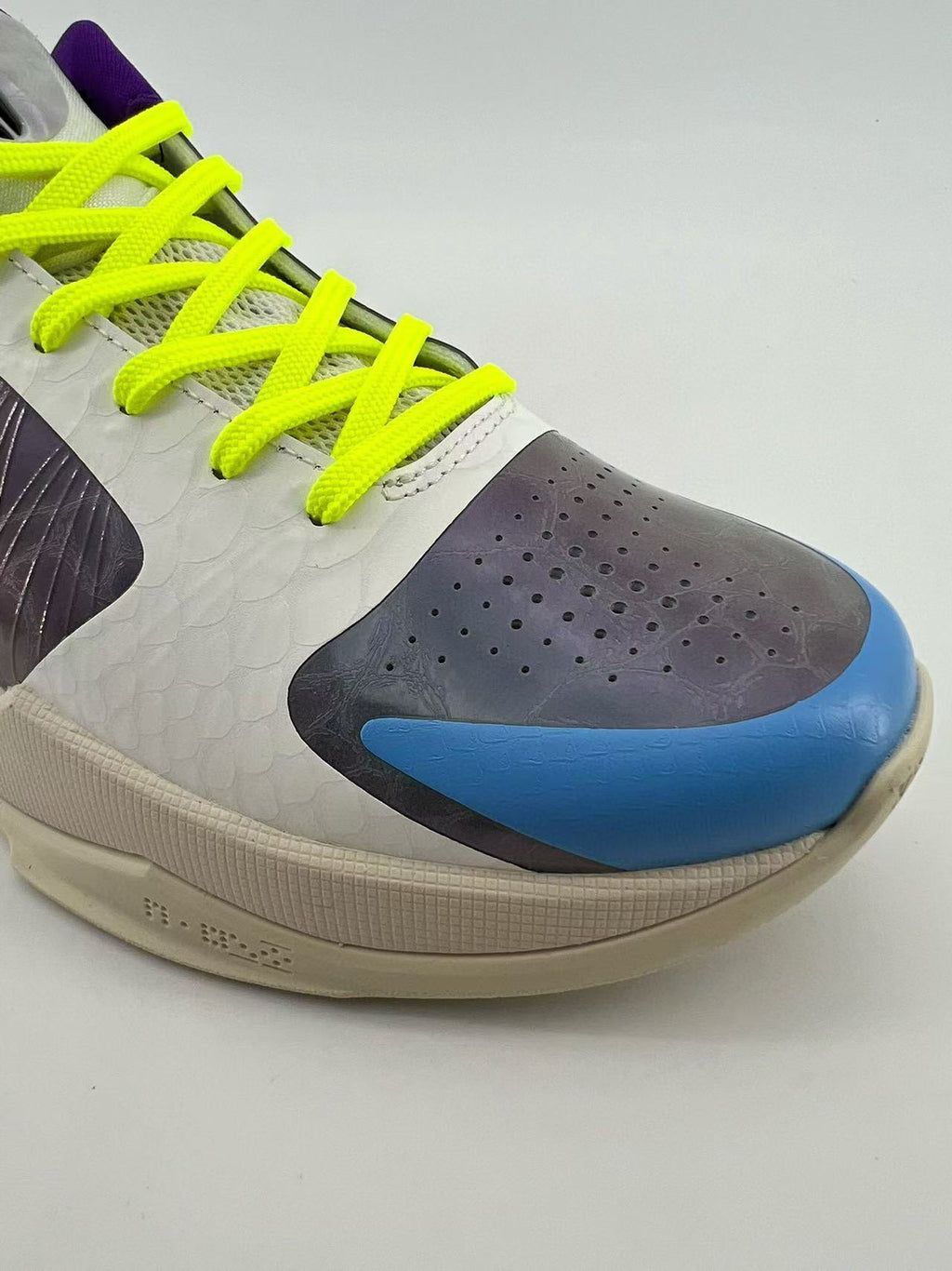 Close-up of the blue toe accent, perforations, and neon yellow laces