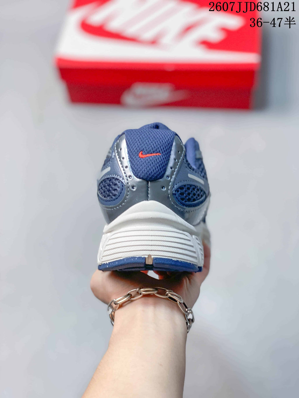 Rear view of a blue and white Nike V5 RNR sneaker showing the padded collar, heel panels and white midsole.