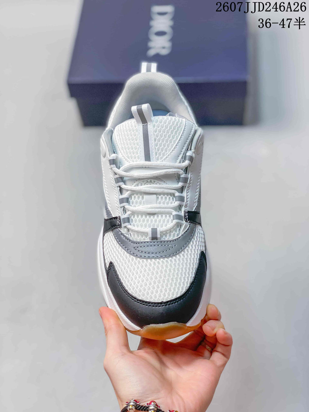Top view of the sneaker showing white laces, gray tongue detailing, and a black toe overlay.