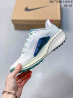 Side profile showing the white textured upper, blue layered side detail, sculpted midsole, and outsole.
