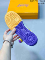 Outsole view showing concentric tread patterns with purple and gold color blocking.