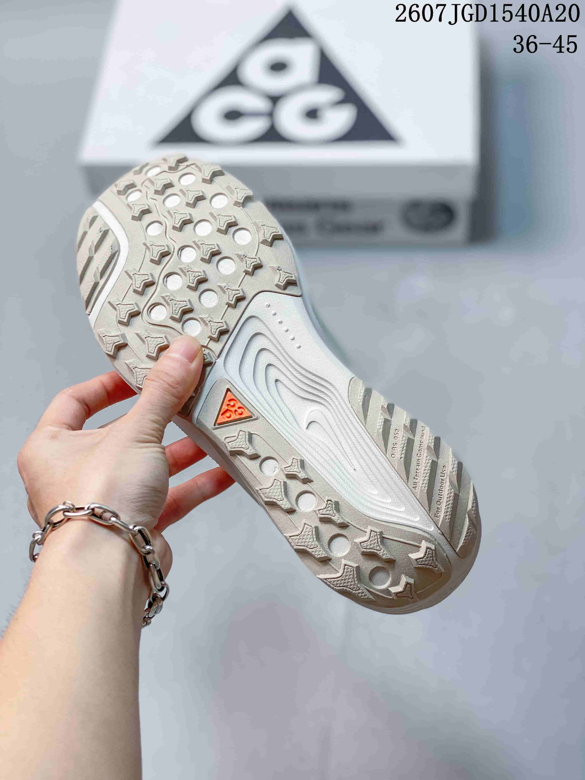 Underside view showing the sneakers' patterned lugged outsole and traction details.