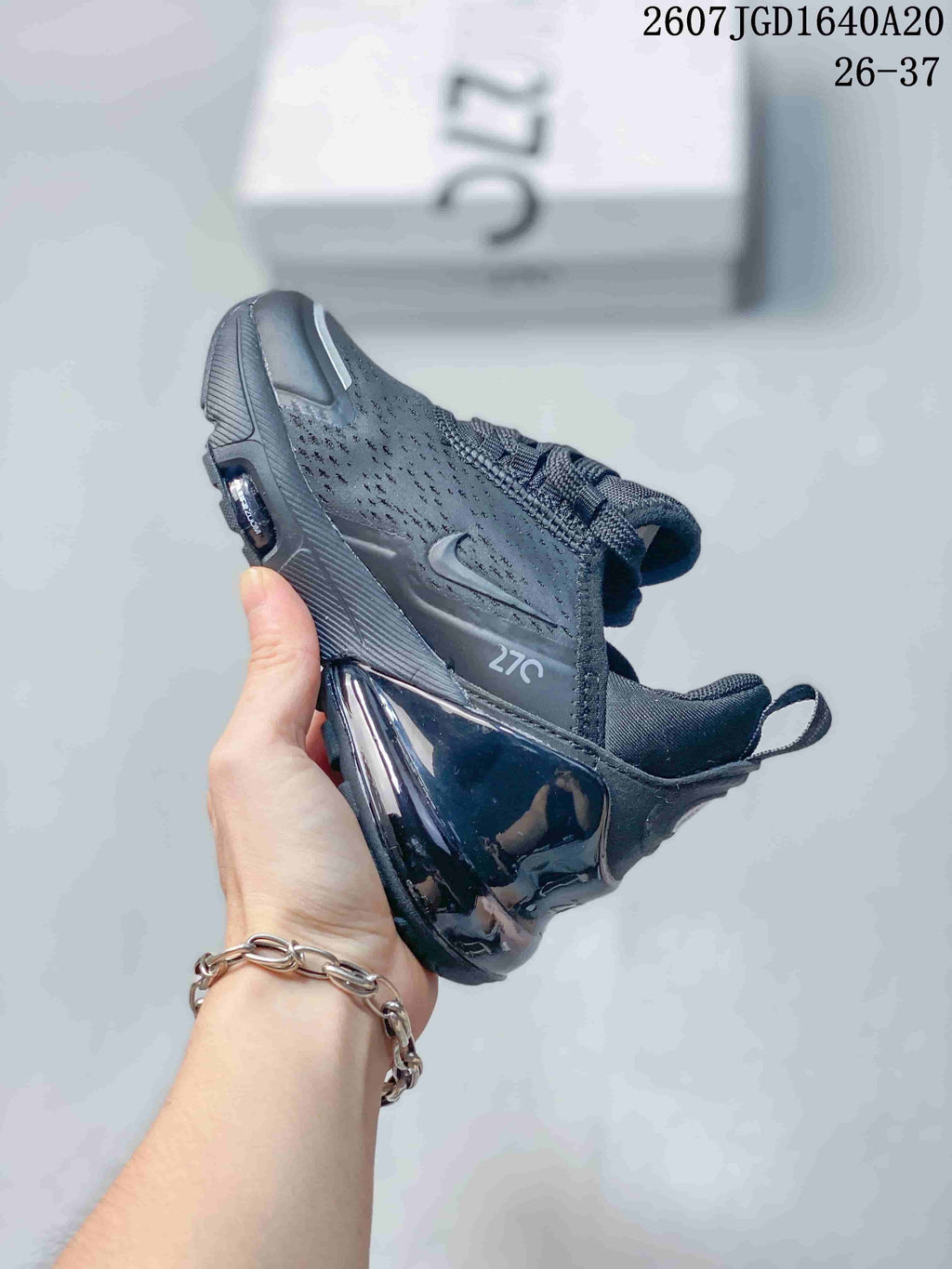 Side profile of the black Nike Air Max 270 sneaker showing the perforated upper, Nike Swoosh, 270 marking, and visible heel air unit.