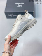 Side view highlighting the light gray upper, layered panels, midsole, and outsole lugs.