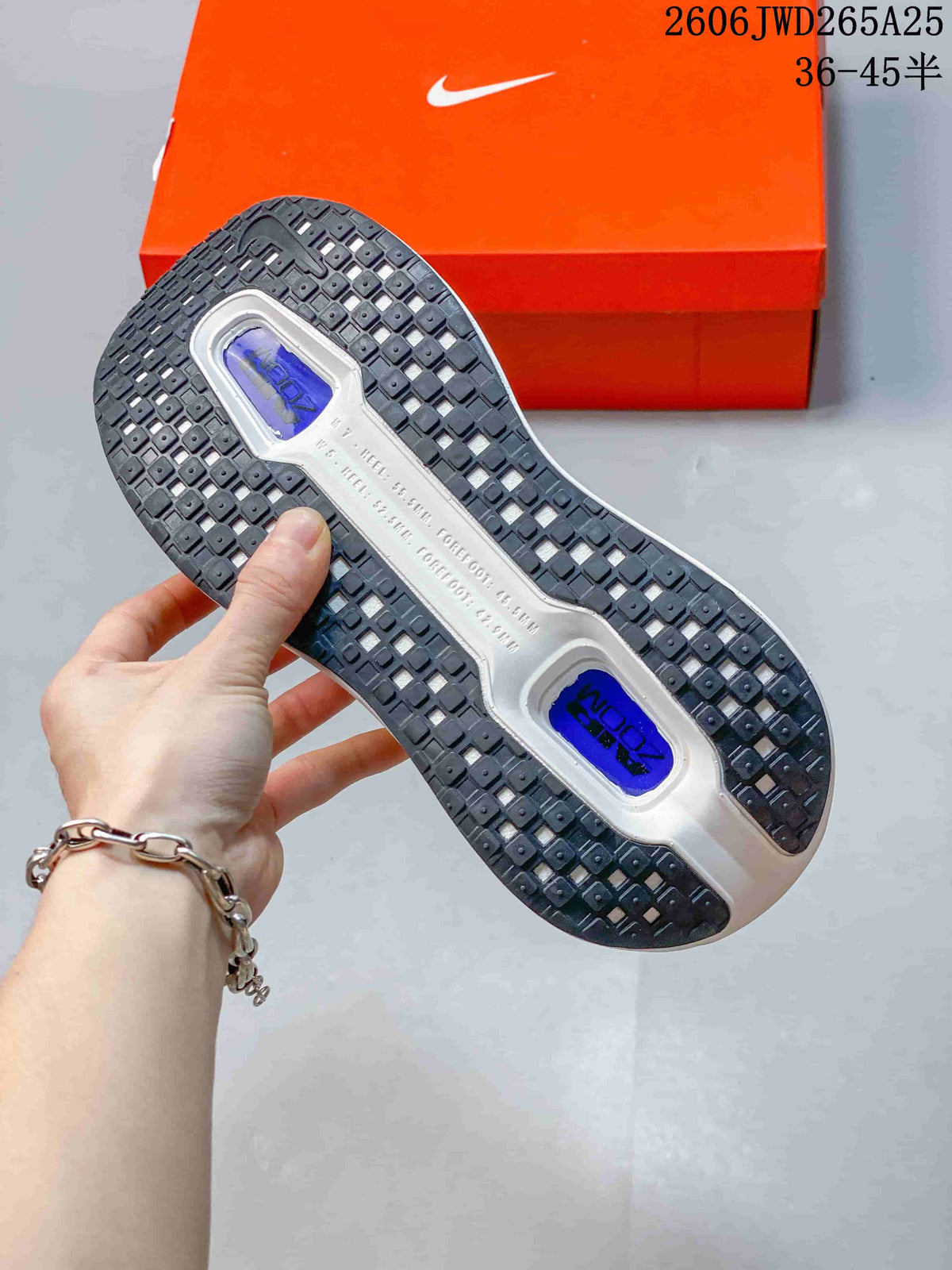 Underside of a Nike Vomero Premium shoe showing a black patterned outsole and blue-colored sections.