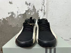 Front view of black lace-up sneakers with white side edges and dark toe guards