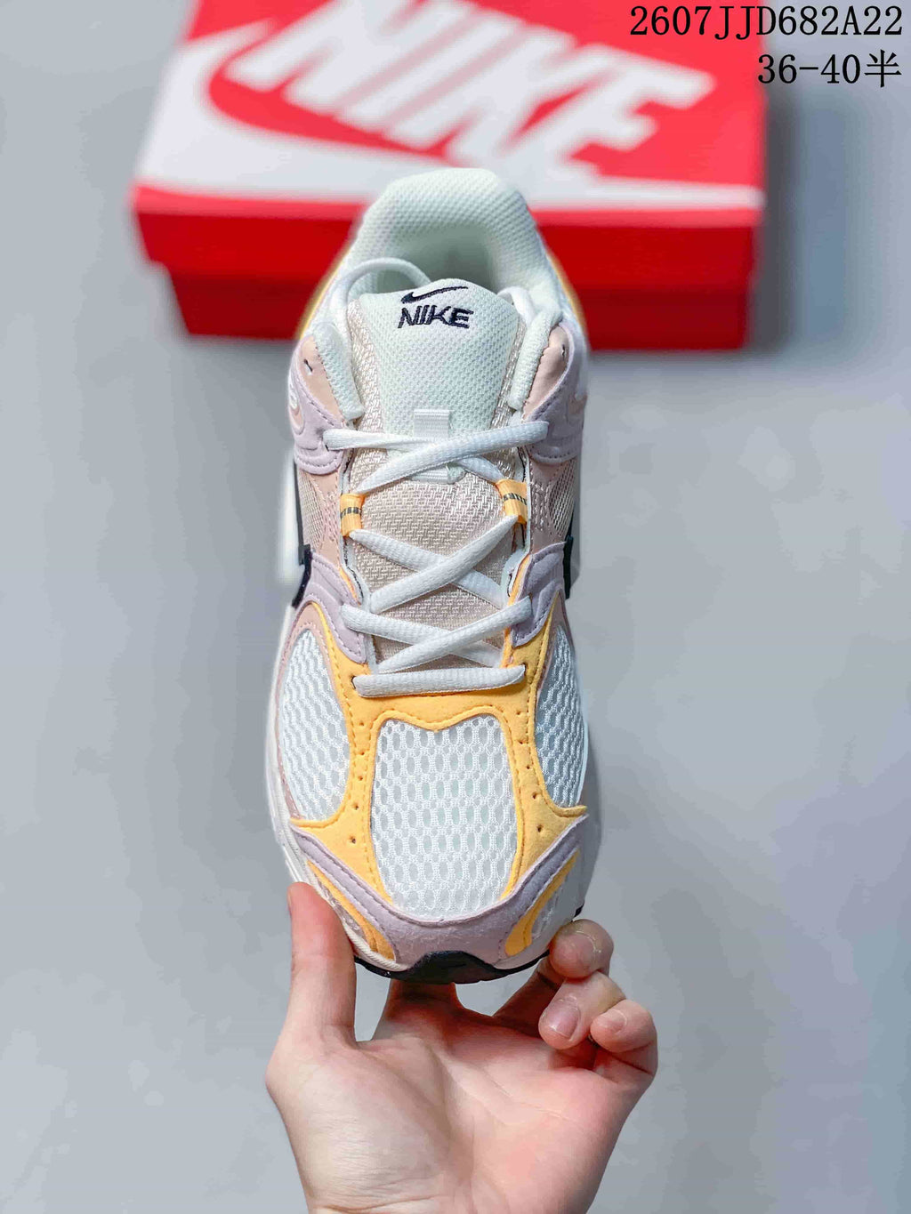 Top-down view of the sneaker showing white laces, a mesh-like tongue and yellow and pink toe overlays; image text shows style code 2607JJD682A22 and size range 36–40.