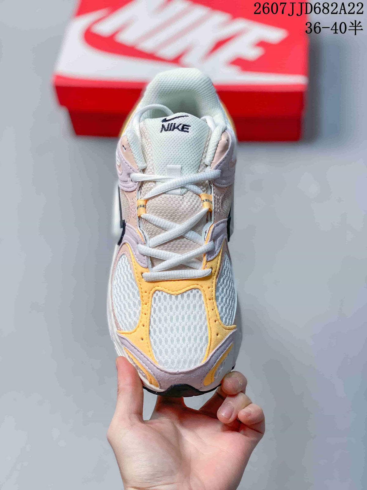 Top-down view of the sneaker showing white laces, a mesh-like tongue and yellow and pink toe overlays; image text shows style code 2607JJD682A22 and size range 36–40.