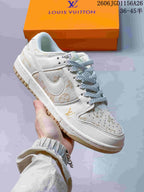 Angled close-up of the ivory and beige patterned sneaker with gold-tone details.
