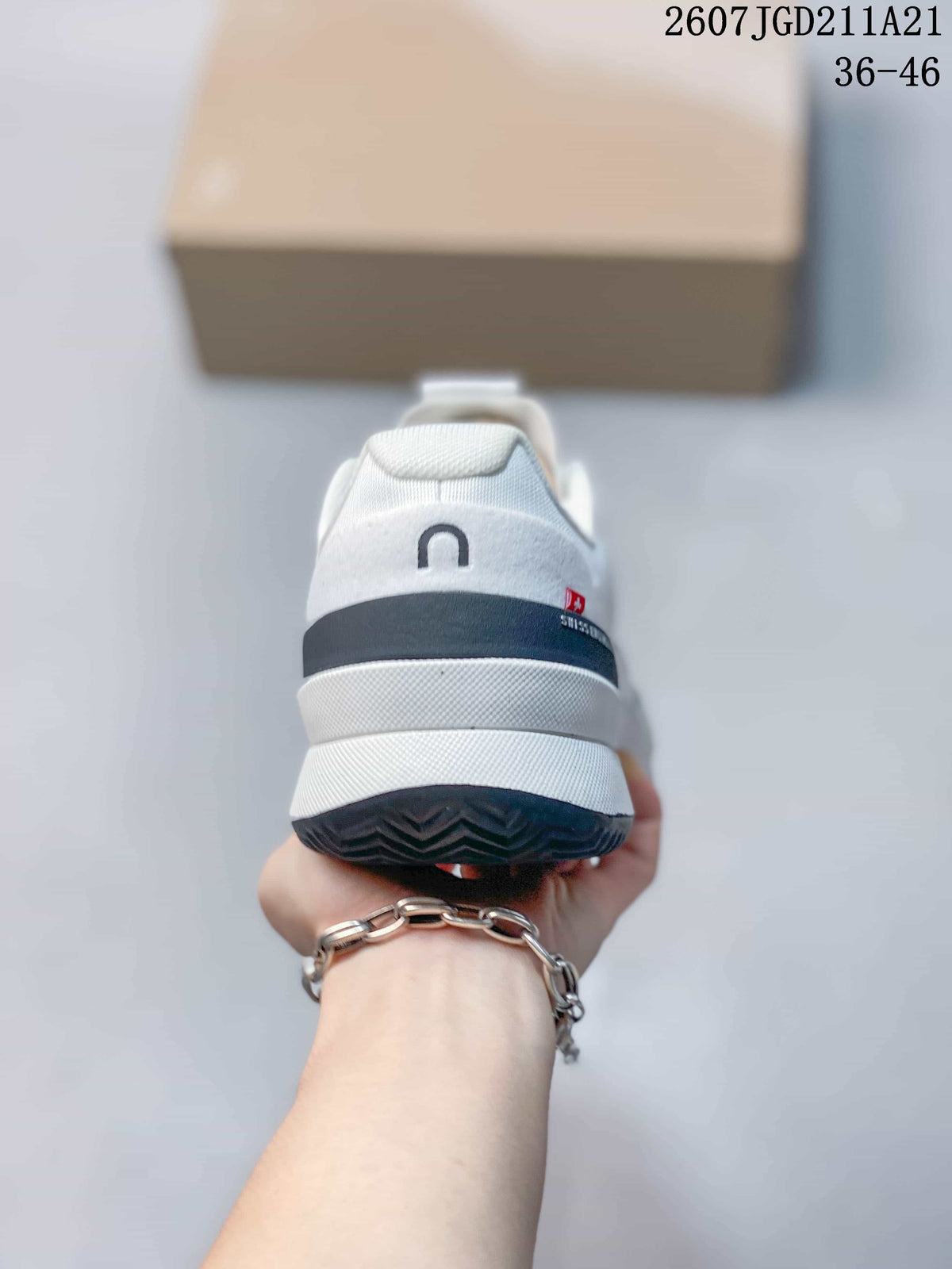 Rear view of the white sneaker showing the padded heel, navy heel accent, and dark outsole.