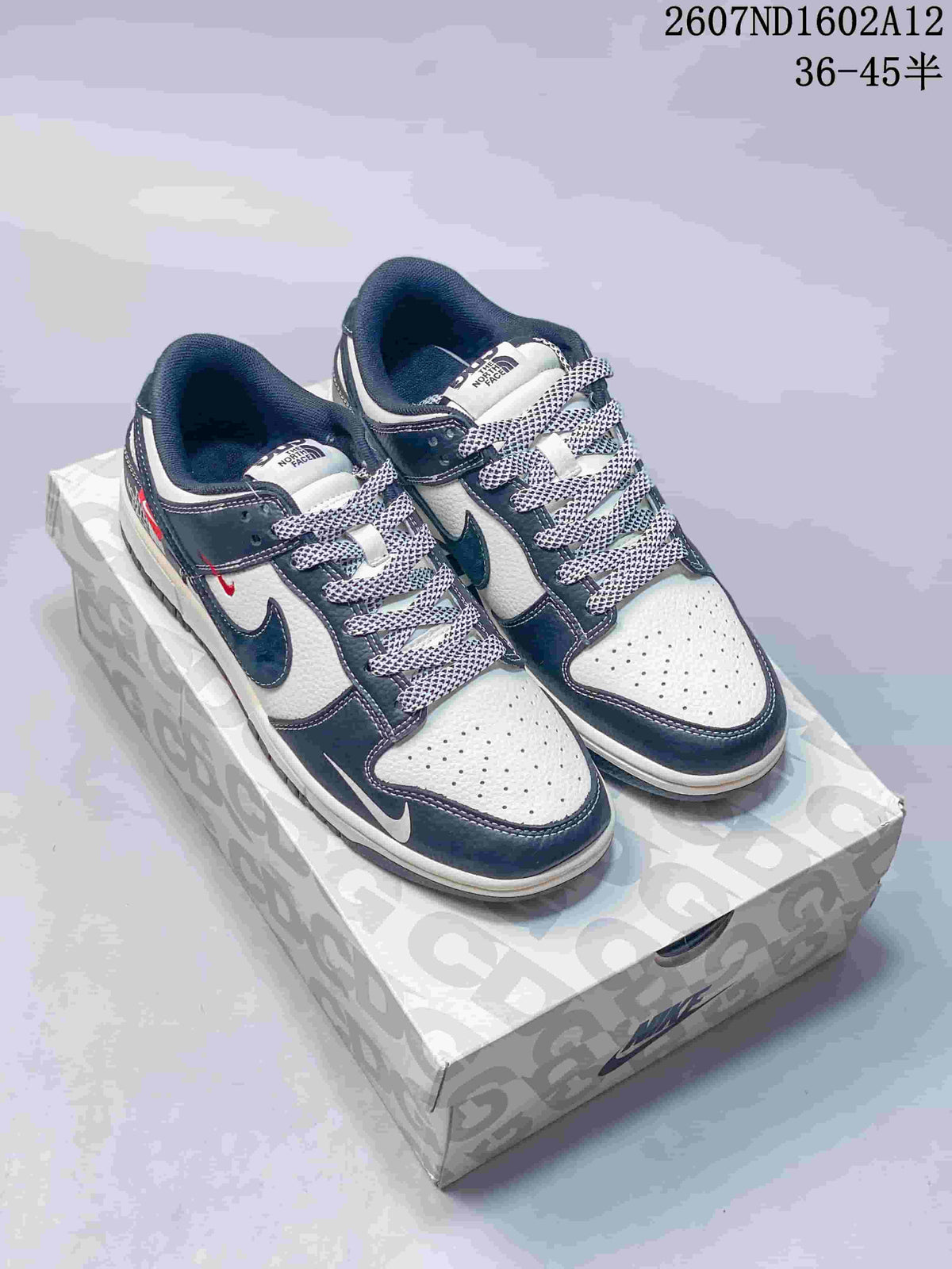 Pair of Nike SB Dunk Low sneakers in an off-white, dark navy and red color-block design, displayed on a patterned shoebox; product code and a 36–45 size range are overlaid in the upper-right corner.