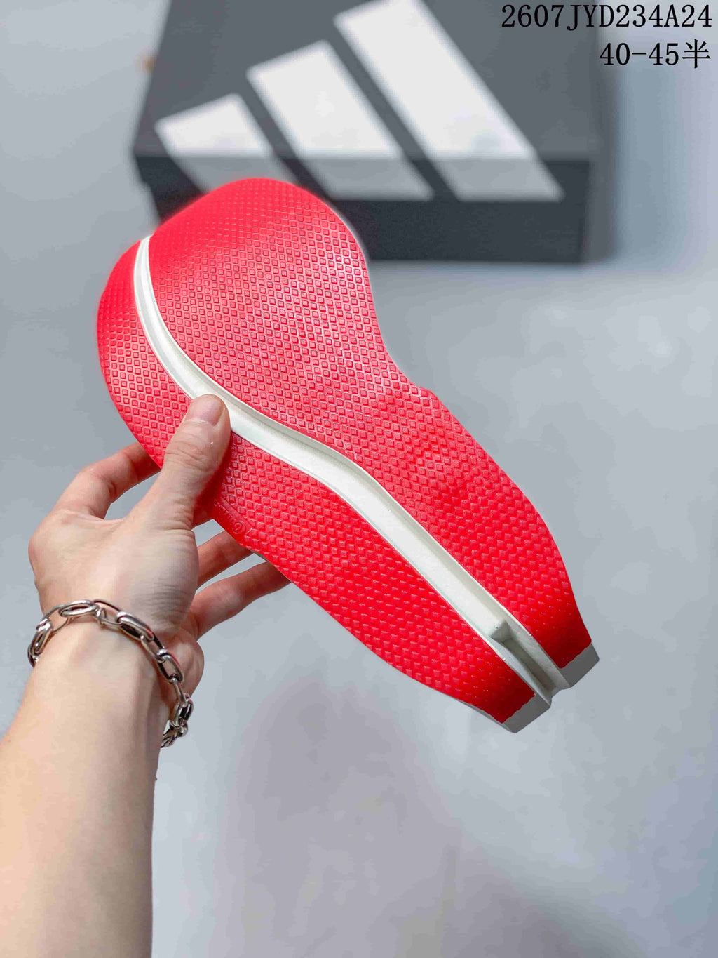 Close view of the red textured outsole pattern on a white running shoe.