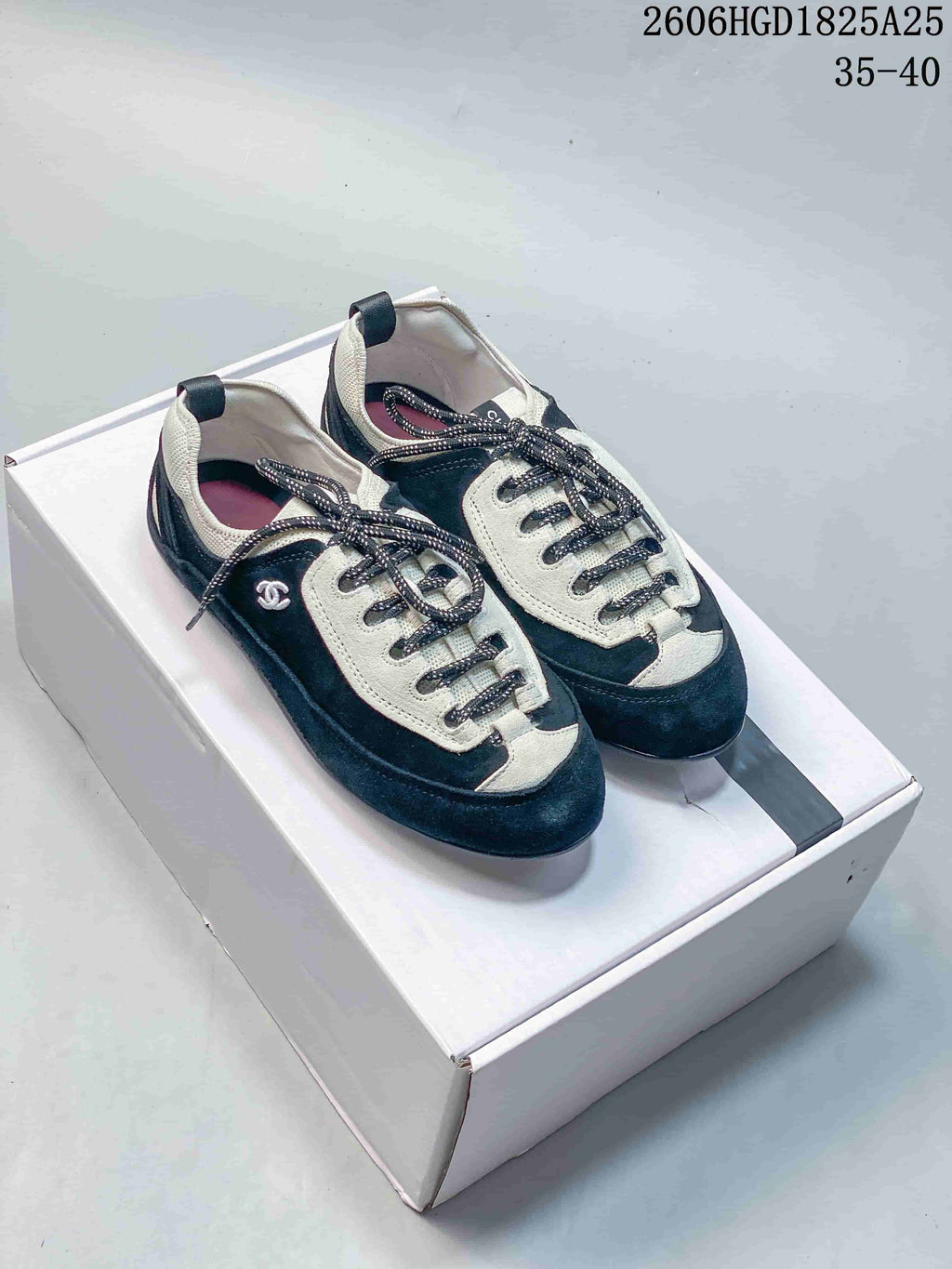 Pair of navy and off-white low-top trainers displayed on a box