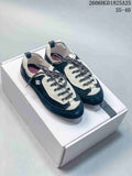 Pair of navy and off-white low-top trainers displayed on a box
