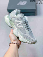 Close side view of a pale mint New Balance 9060 sneaker, showing mesh inserts, layered overlays and the chunky outsole.