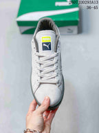 Top view of a white lace-up sneaker with a contrasting PUMA tongue label and gray collar lining.