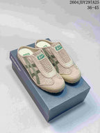 Pair of beige and green Onitsuka Tiger Mexico 66 Sabot sneakers displayed on a shoe box.