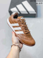 Brown and white adidas Adipista low-top sneaker shown at an angle with matching brown laces and stitched panels.