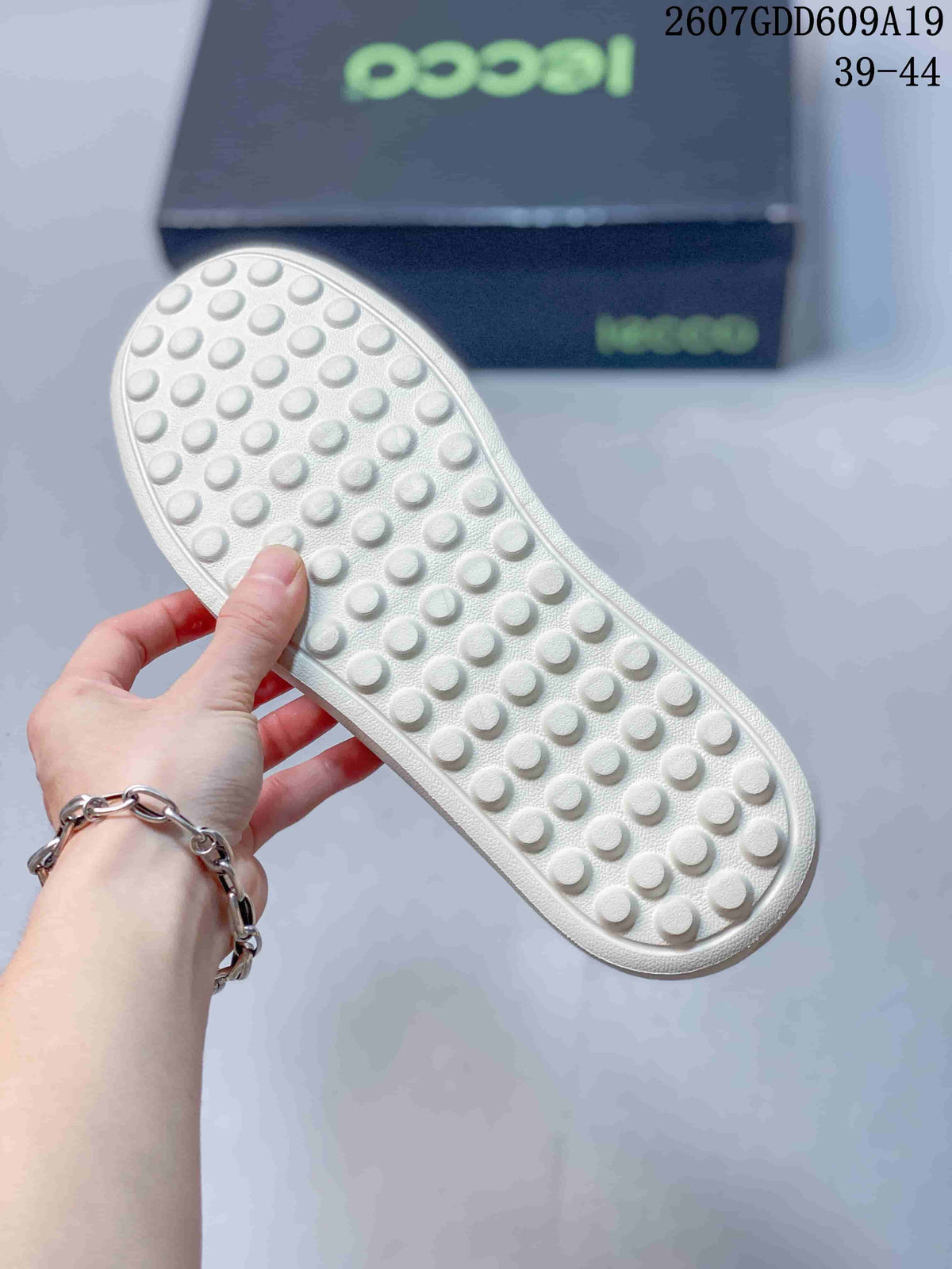 Close-up of the light-colored outsole showing a raised circular tread pattern.