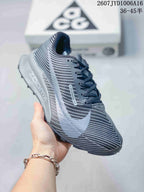 Angled side view highlighting the striped gray upper, Nike branding, and layered sole.