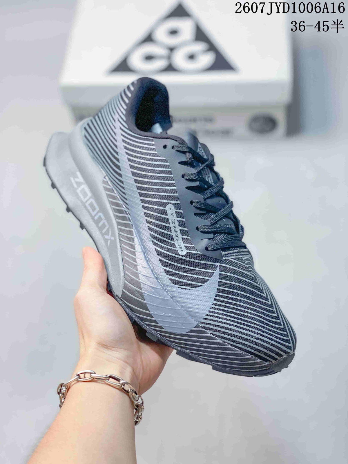 Angled side view highlighting the striped gray upper, Nike branding, and layered sole.