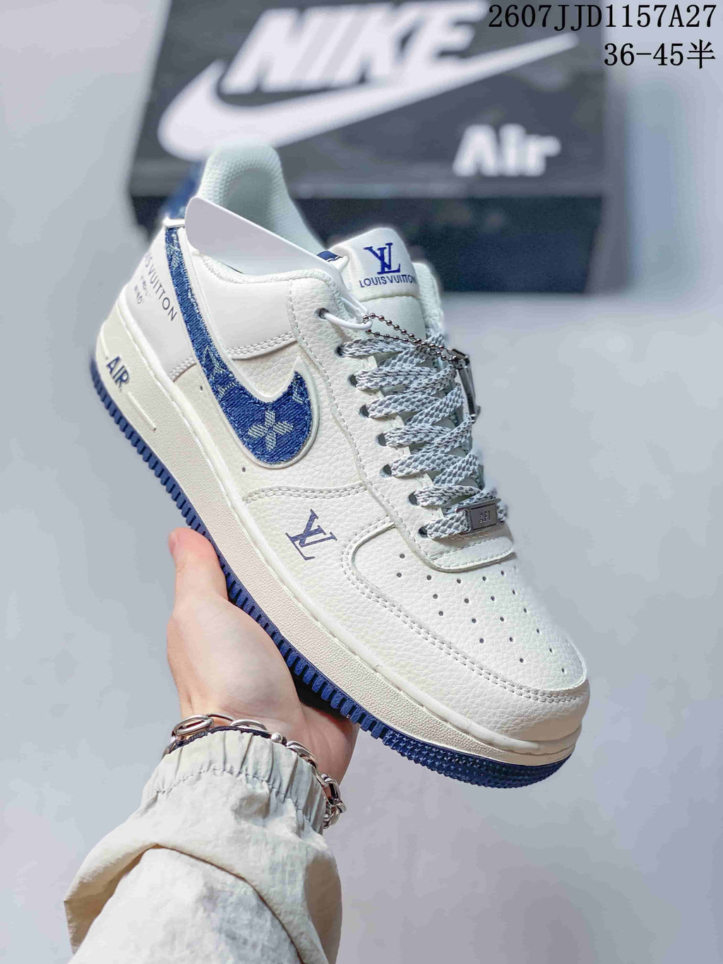 Angled side view showing the white upper, blue accents, patterned laces, decorative branding, and blue outsole.