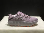 Side view of a single purple Nike Mind 002 sneaker with orange outsole details.