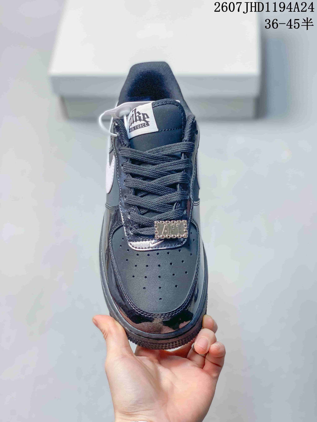 Top view of the sneaker showing the perforated toe box, black laces, tongue label and decorative lace accessory.