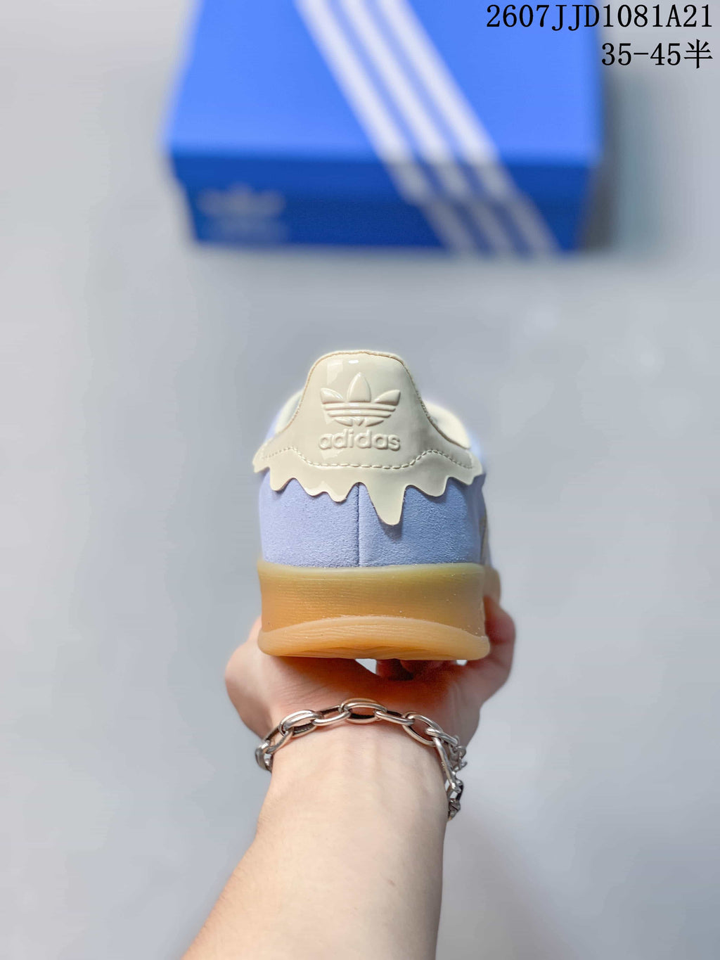 Rear view showing the cream heel tab, adidas branding, light blue upper, and gum outsole.