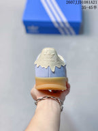 Rear view showing the cream heel tab, adidas branding, light blue upper, and gum outsole.