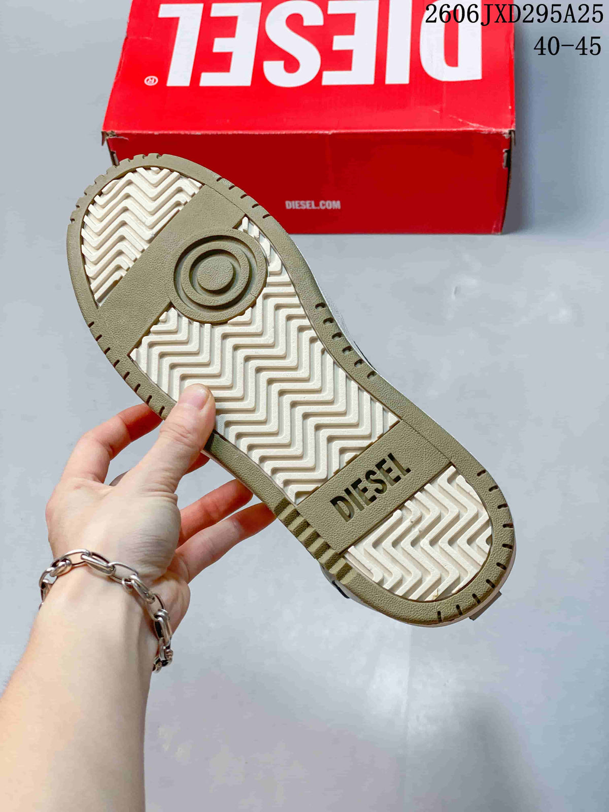 Underside of the sneaker showing a patterned white and khaki-colored sole