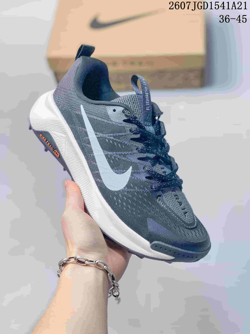 Angled side view of the Nike Wildhorse 10 sneaker showing the dark gray upper, white Swoosh, white midsole, and lugged outsole.
