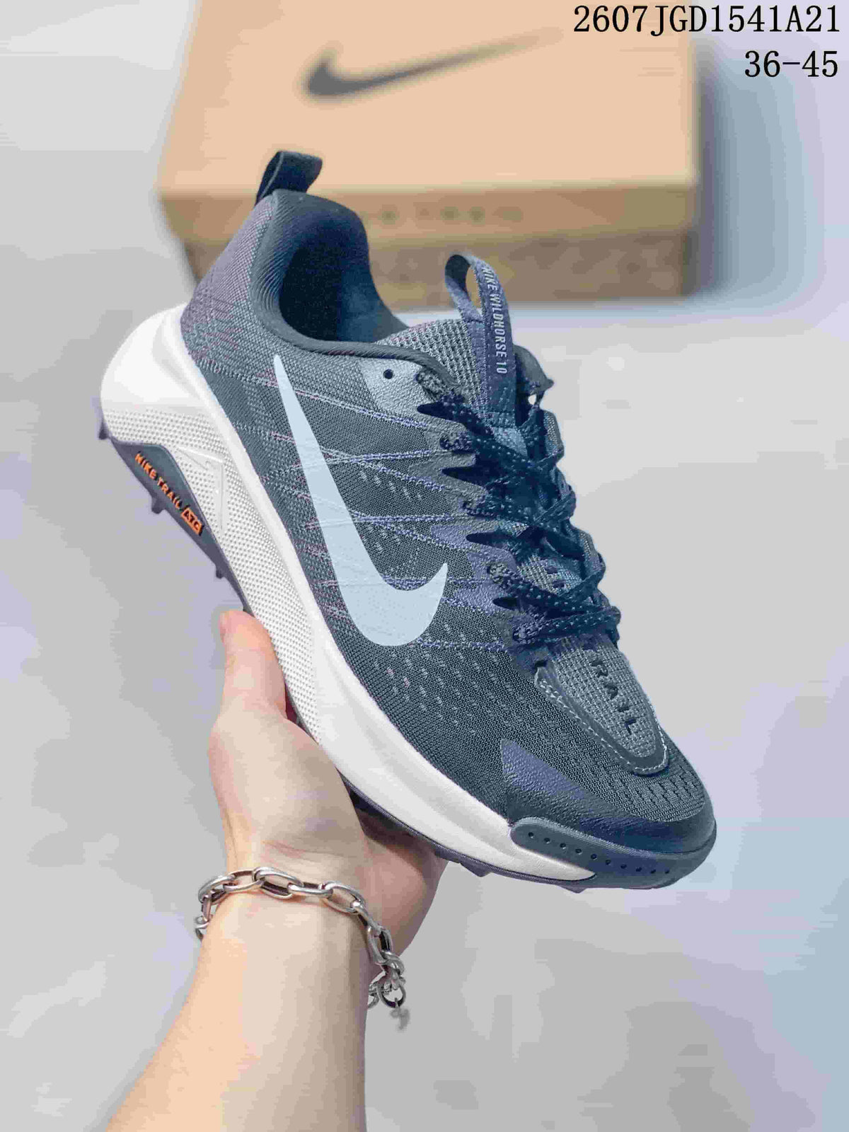Angled side view of the Nike Wildhorse 10 sneaker showing the dark gray upper, white Swoosh, white midsole, and lugged outsole.
