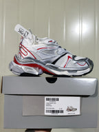 Side profile of the sneaker displayed on its box; the box label identifies 9160 Runner 2, White/Grey/Red, and size C 37.