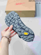 Close view of the rugged outsole with multidirectional tread, molded channels, and visible Vibram branding.