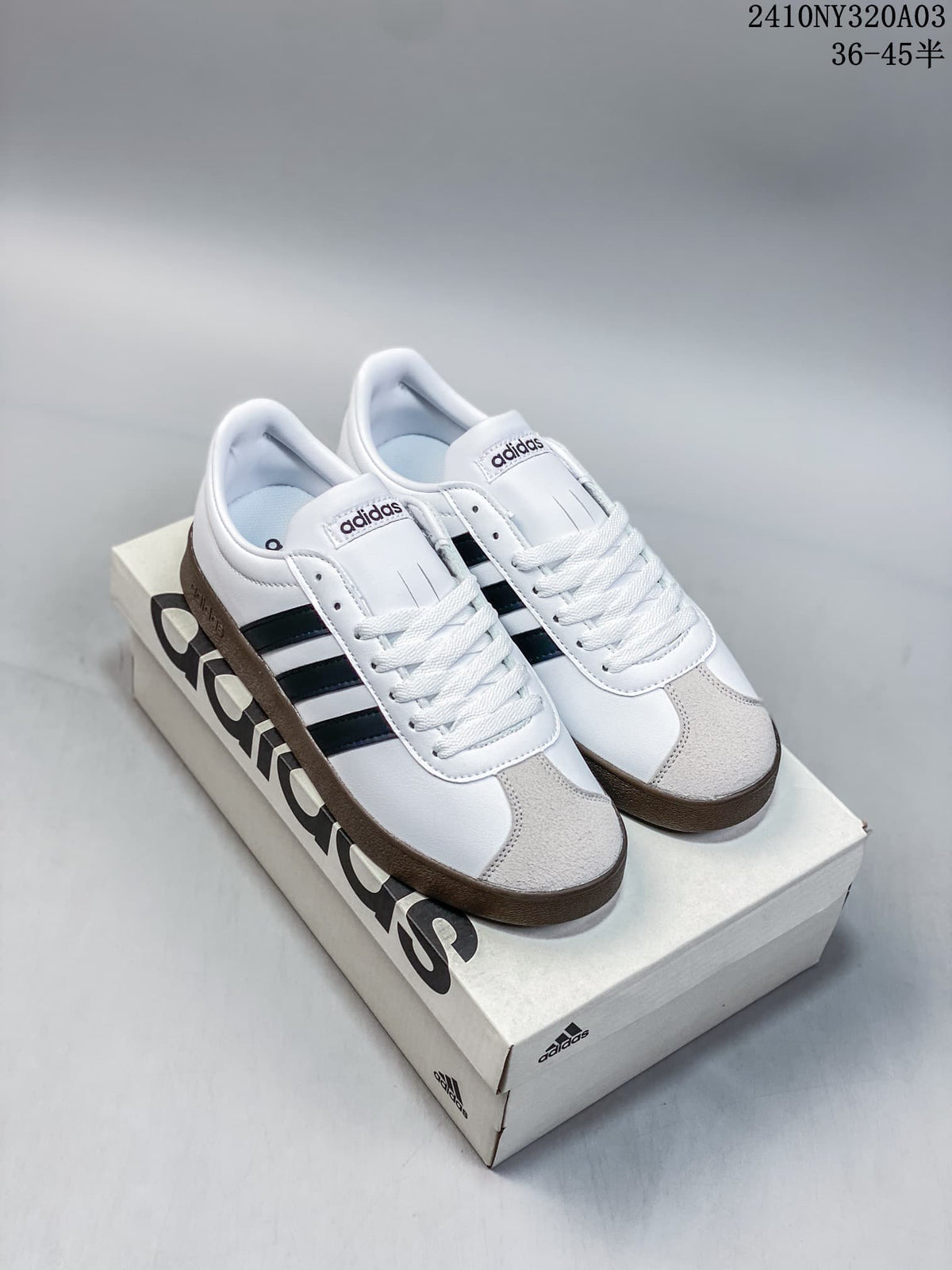 Pair of white Adidas Neo VL Court 2.0 sneakers with black side stripes and gum-colored soles displayed on an Adidas shoebox.