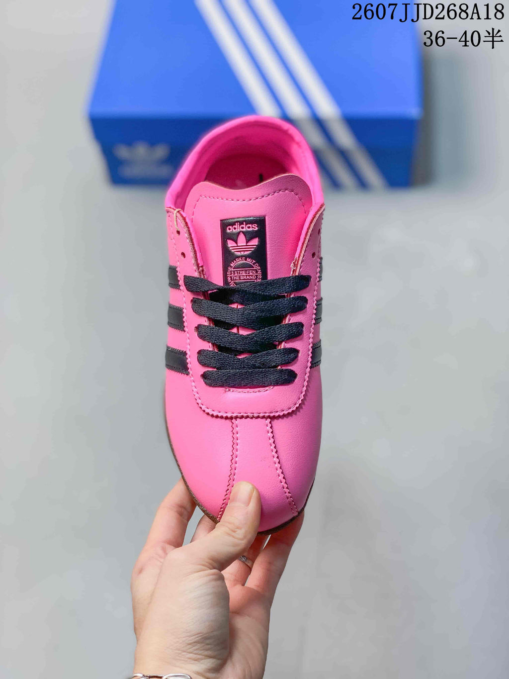 Top view of the pink sneaker showing the black laces, tongue label, and stitched toe panel.