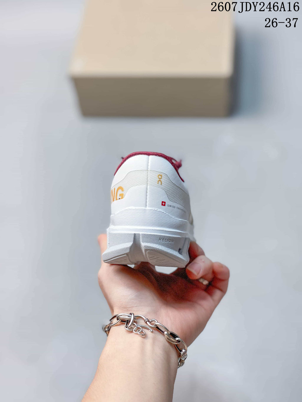 Rear view of a white kids' running shoe showing the heel branding, burgundy collar trim, and layered outsole.