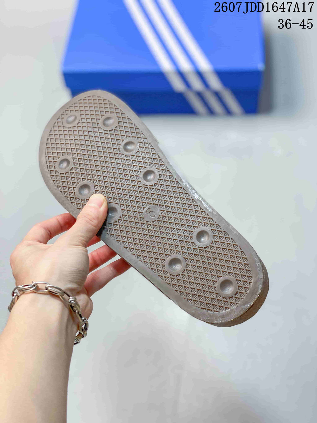 Underside of the clog showing a textured outsole with a grid pattern and circular traction elements.