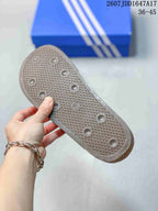 Underside of the clog showing a textured outsole with a grid pattern and circular traction elements.