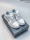 Pair of white and light gray low-top sneakers with perforated toes and contrasting Swoosh details, shown on a box.