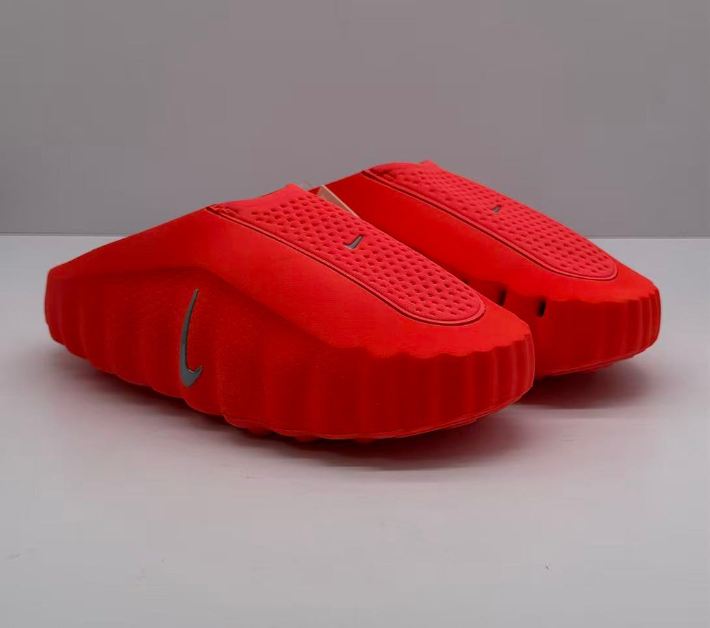 Pair of orange-red Nike slides shown from a front three-quarter angle.